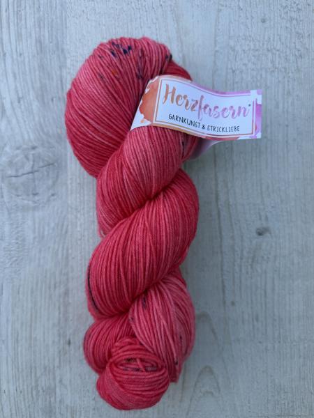 Herzfasern No. 21 Korallenherz – handgefärbtes Garn aus extrafeiner Merinowolle und Polyamid in Koralle, Himbeerrosa und Pink mit feinen dunklen Sprenkeln.